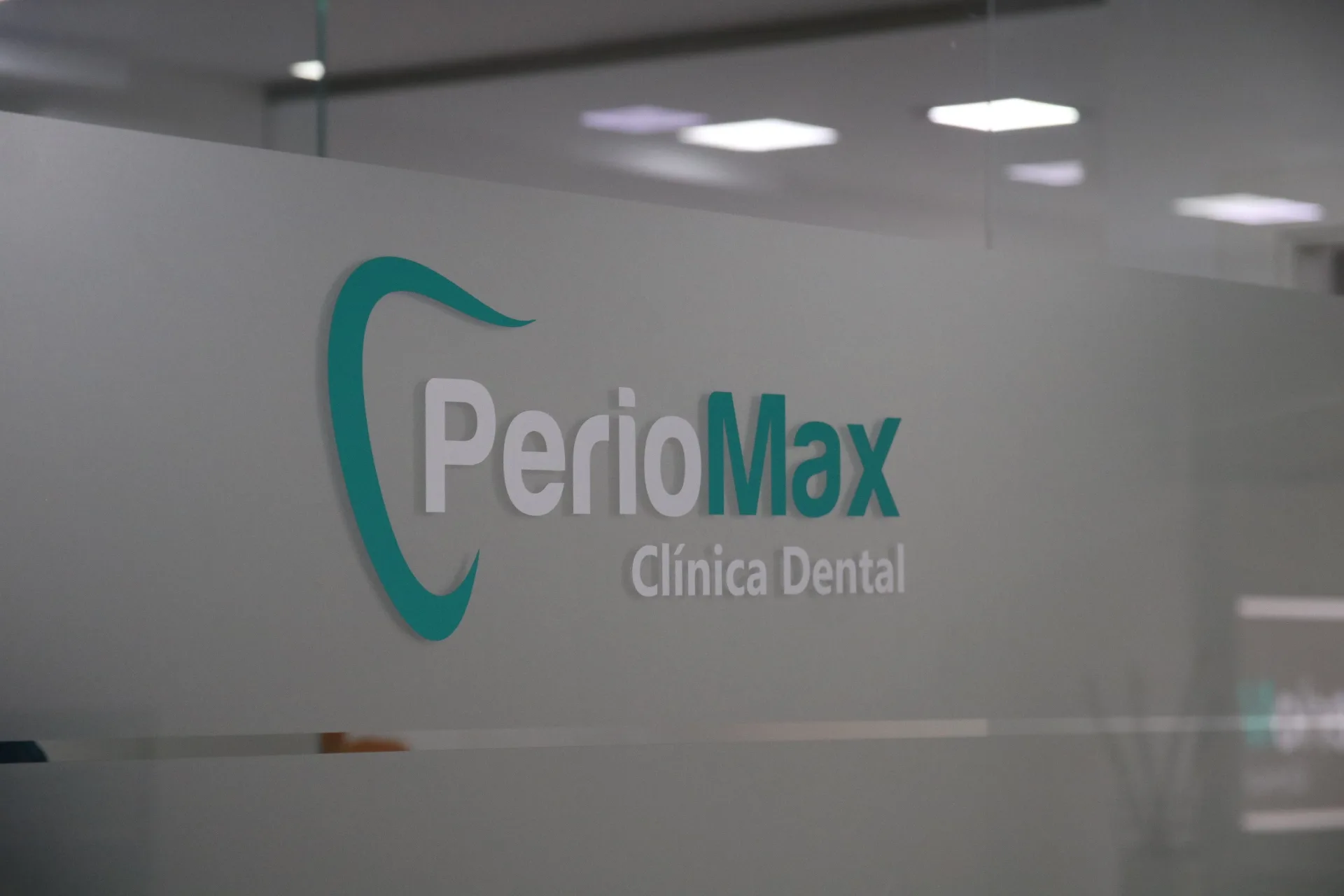 Logo PerioMax en cristal de la clínica