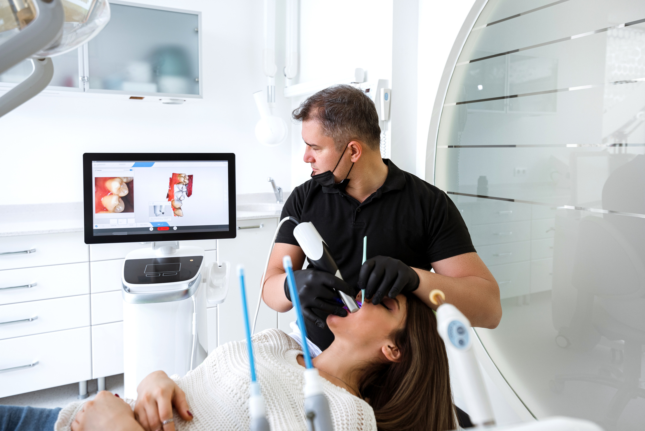 Dentist scanning patient's teeth with a CEREC scanner