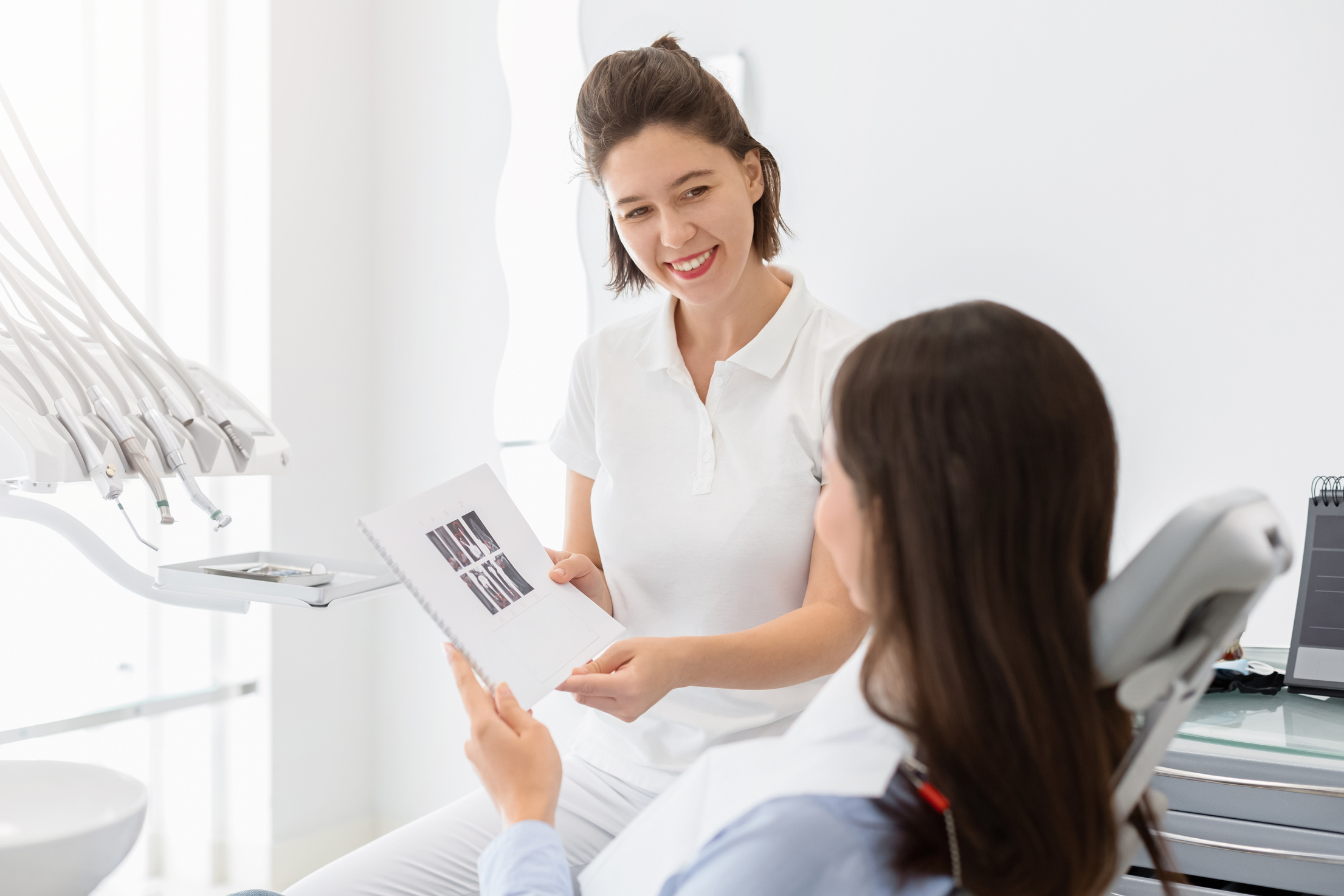 Cheerful dentist giving patient educational dental brochure