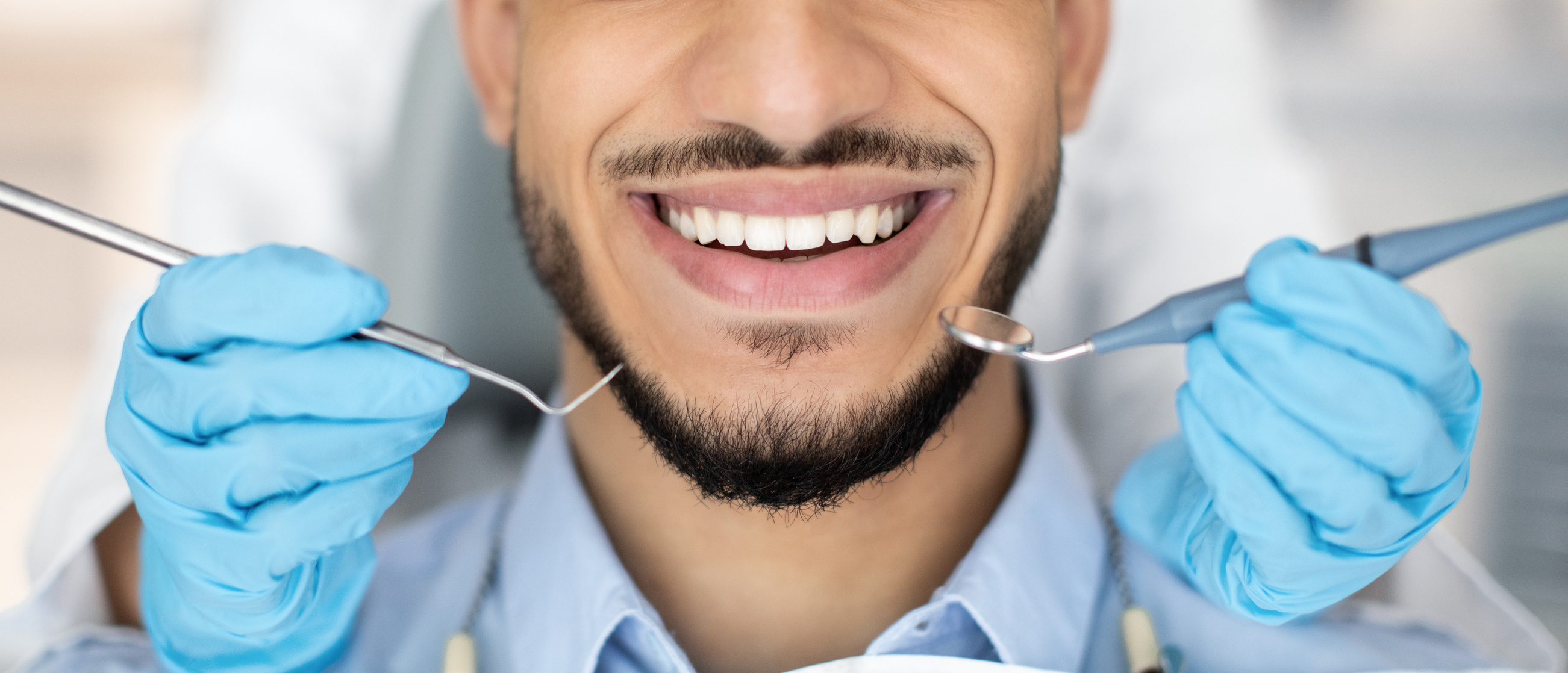 Periodontal Services. Closeup Shot of Smiling Man Getting Treatment in Stomatologic Clinic